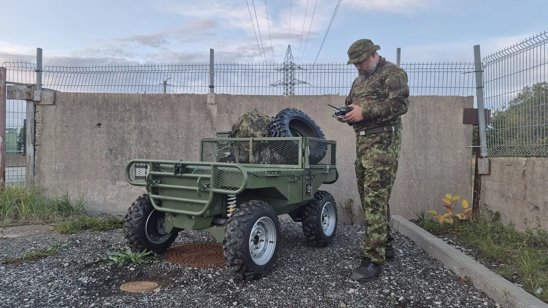 An operator stands beside Badger with a handheld controller. The vehicle is roughly waist height.